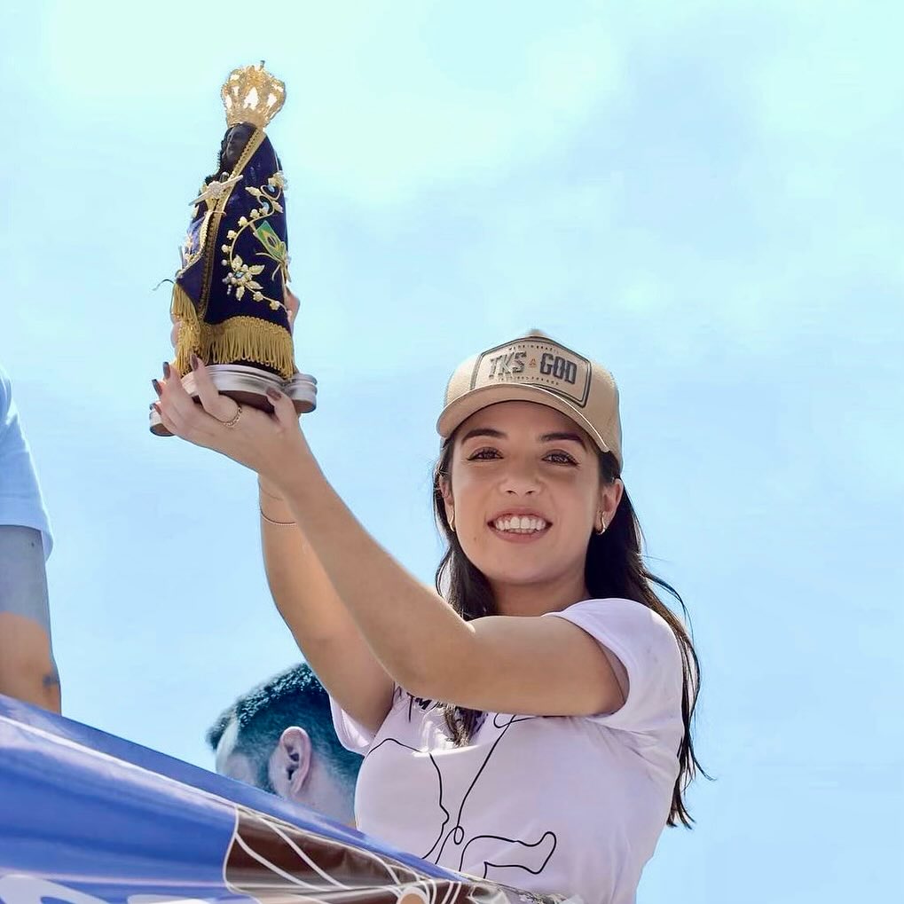 Chiara Biondini erguendo a imagem de Nossa Senhora Aparecida em um ato público